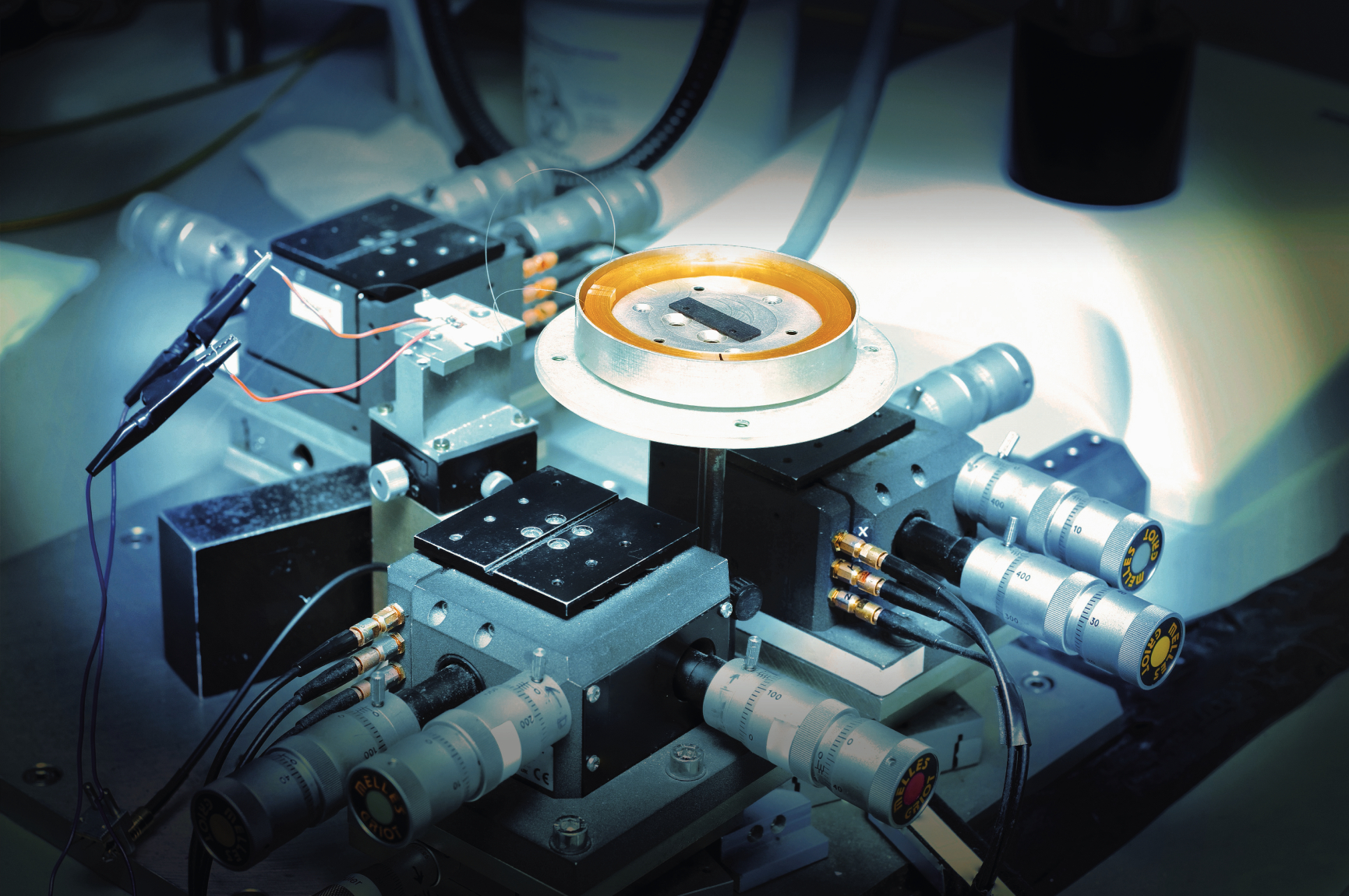 An optical-fibre coil surrounded by instruments on an Exail laboratory bench